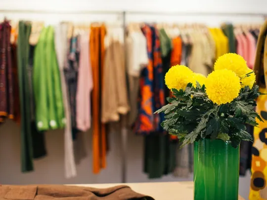 Colourful garments on a rack inside a boutique