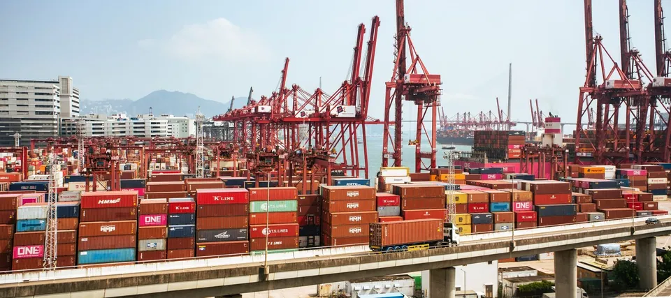 Cargo containers and red cranes at a Hong Kong port