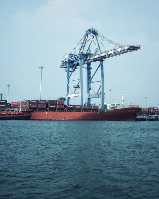 Container ship beneath a loading crane at an industrial port